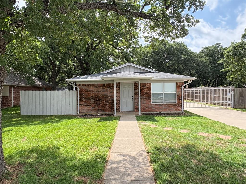 a front view of a house with a yard and trees