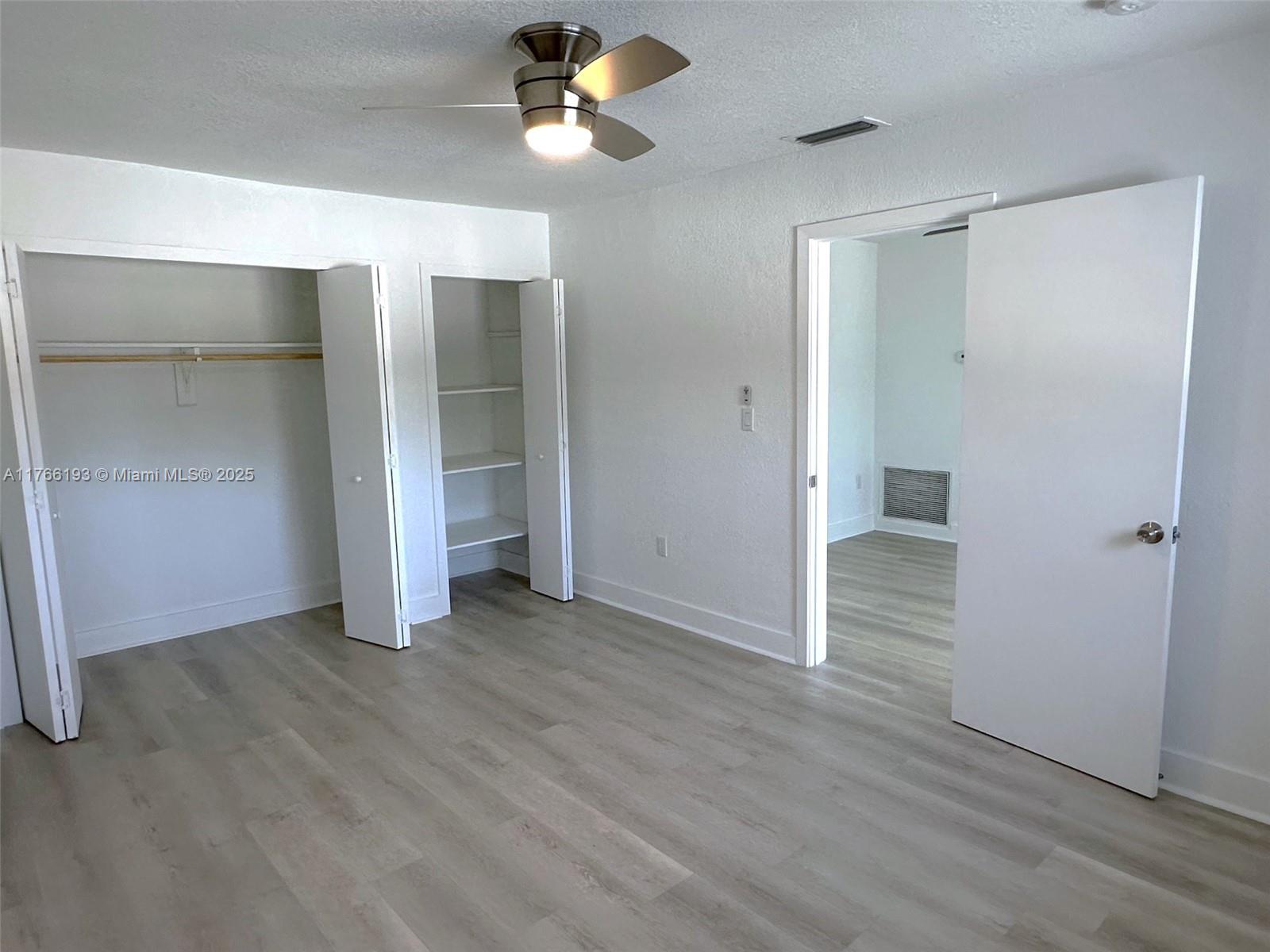 11232 Southwest 5th Street, Unit 2 Sweetwater, FL 33174 - Photo 12 of 24 an empty room with wooden floor and closet