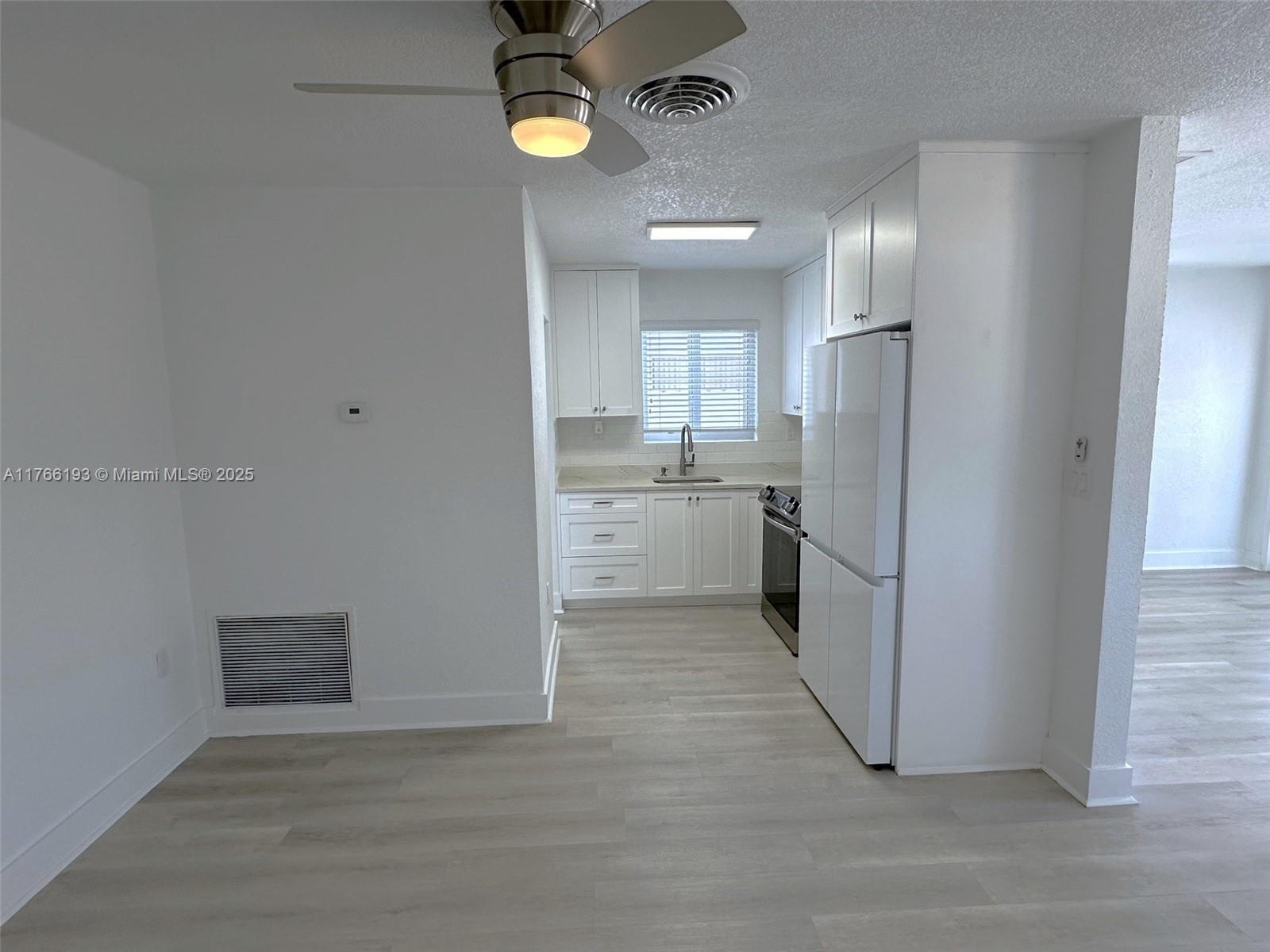 11232 Southwest 5th Street, Unit 2 Sweetwater, FL 33174 - Photo 6 of 24 an empty room with kitchen appliances and cabinets