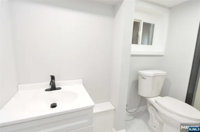 a bathroom with a sink a toilet and mirror