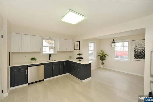 a large kitchen with granite countertop a large counter top space a sink a window and stainless steel appliances