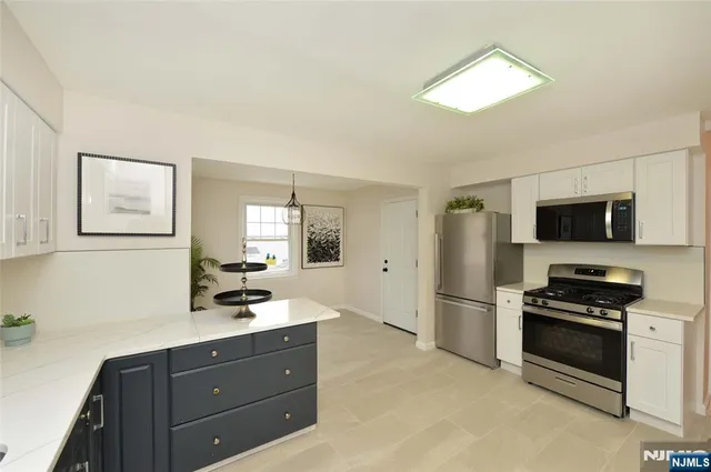 a kitchen with stainless steel appliances a stove microwave and refrigerator