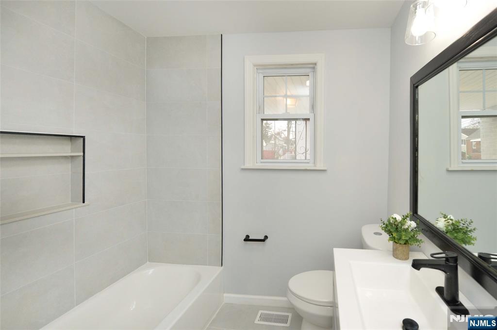 16 Liberty Street Little Ferry, NJ 07643 - Photo 7 of 16 a bath room with a toilet a sink and a bath tub