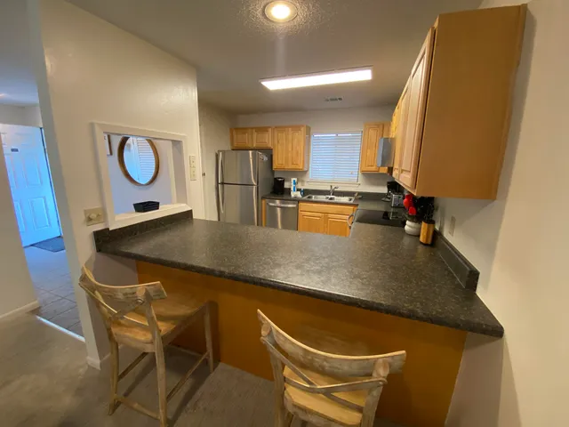 a bedroom with bed and a view of kitchen
