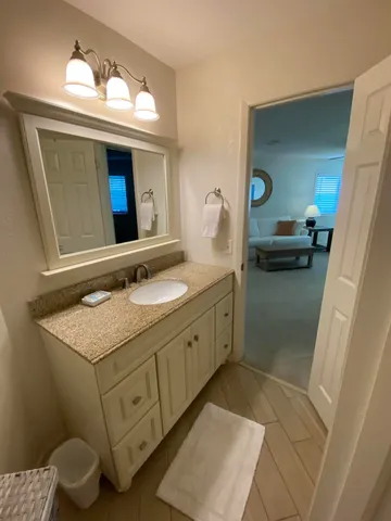 a bedroom with a bed and a lamp with the dresser