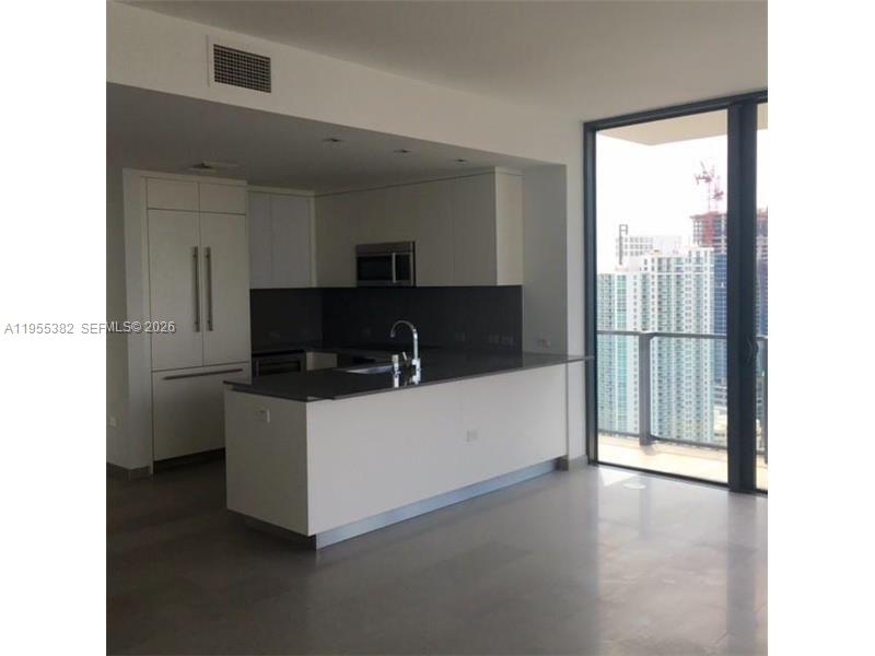 68 Southeast 6th Street, Unit 3502 Miami, FL 33131 - Photo 2 of 16 a living room with stainless steel appliances kitchen island granite countertop a refrigerator and a stove