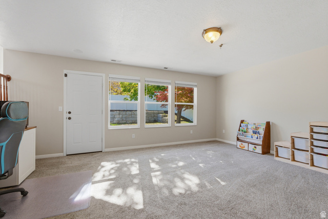 11189 Ohenry Road East Sandy, UT 84070 - Photo 22 of 44 Carpeted interior space featuring a white paneled door, three transom windows, light neutral wall paint, and a semi-flush mount ceiling light fixture