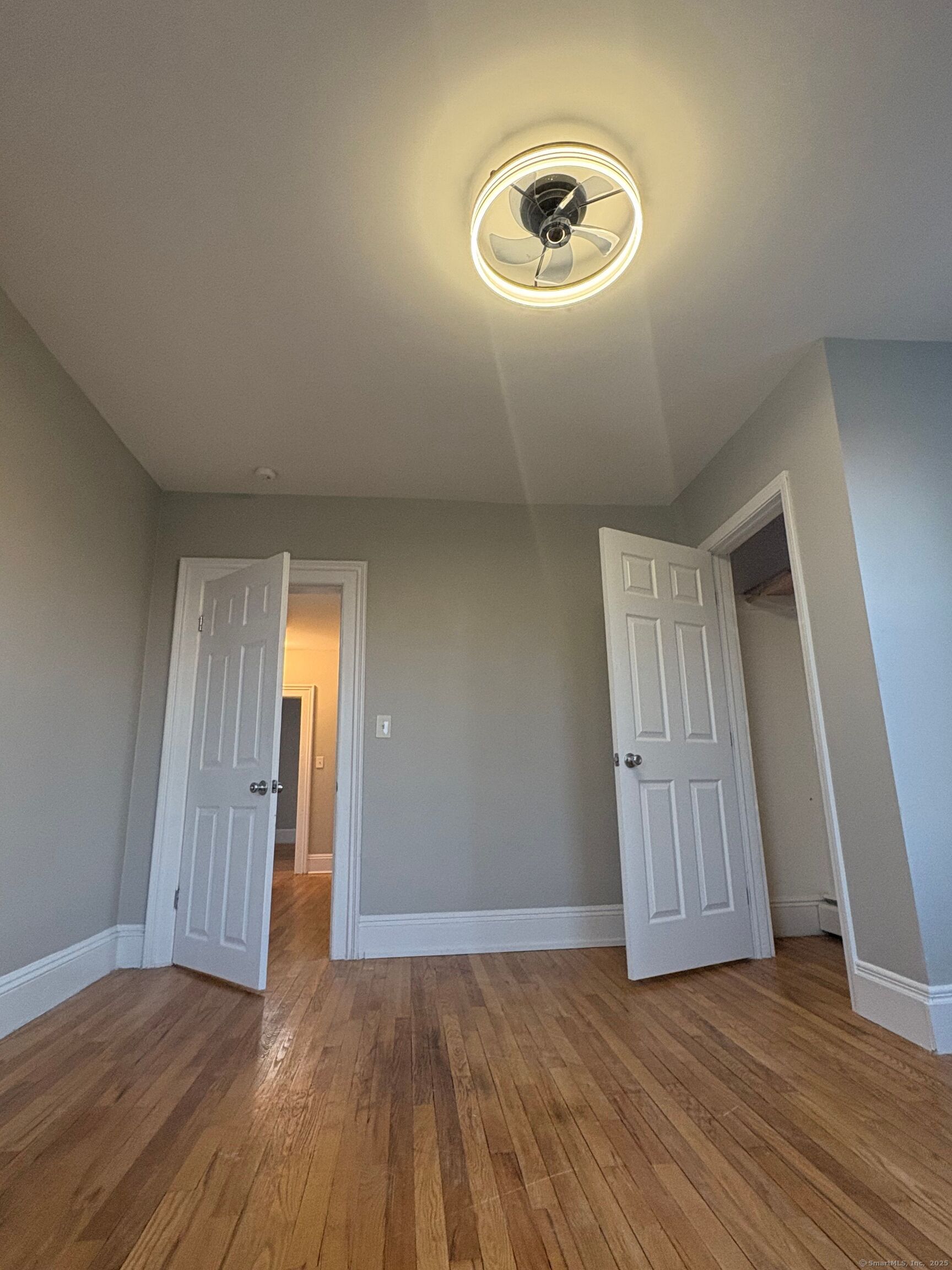818 Pine Street, Unit 14 Bristol, CT 06010 - Photo 13 of 15 an empty room with wooden floor and windows
