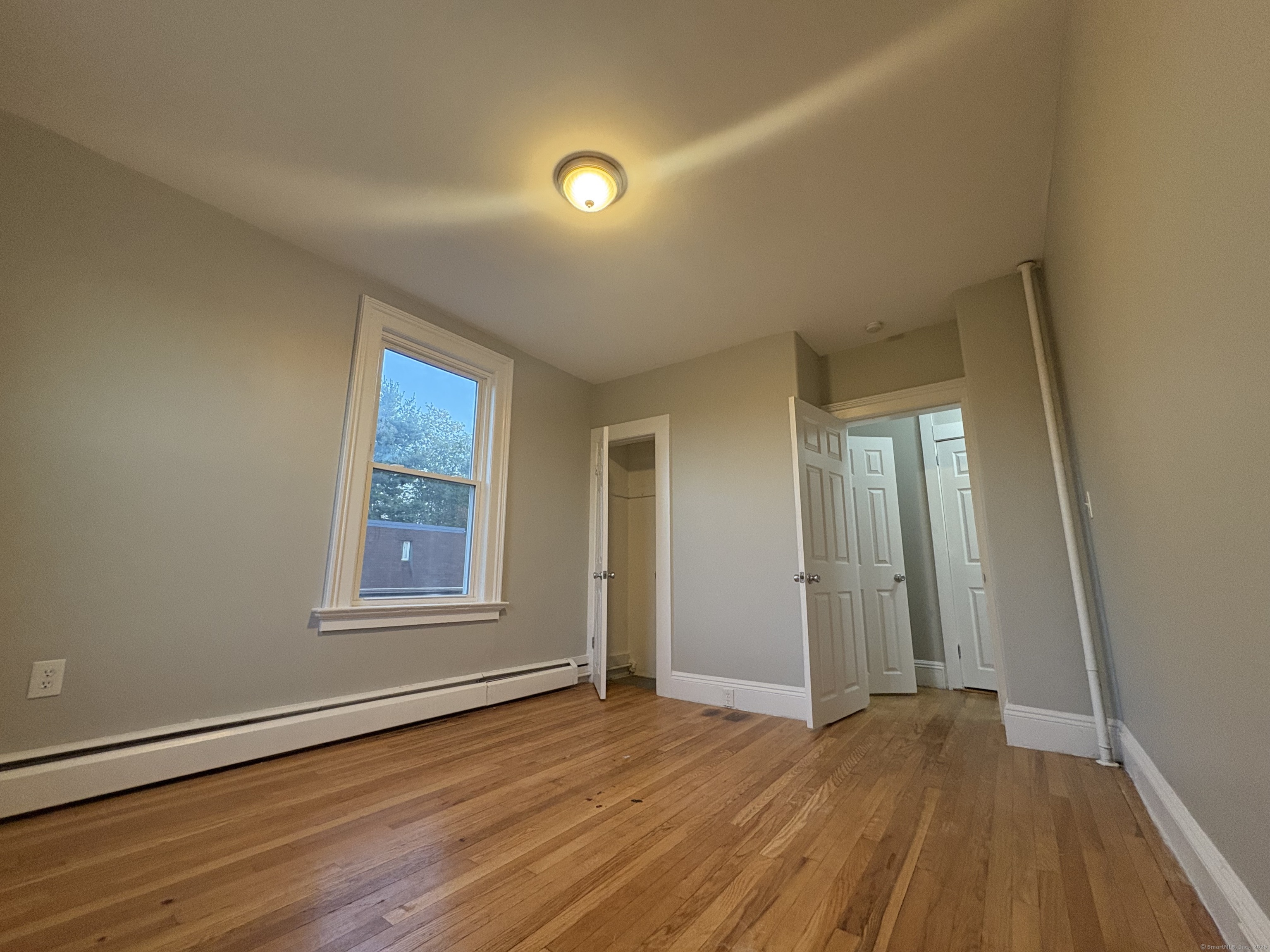 818 Pine Street, Unit 14 Bristol, CT 06010 - Photo 15 of 15 an empty room with wooden floor and windows