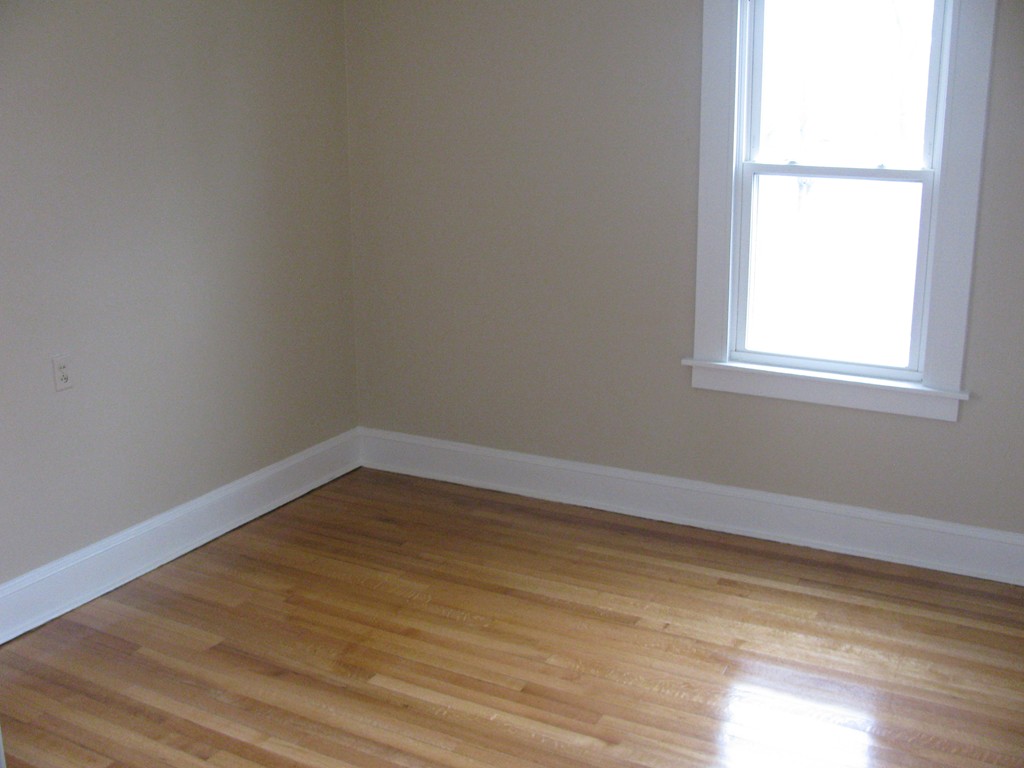 228 Edendale Street Springfield, MA 01104 - Photo 12 of 19 a view of an empty room with wooden floor and a window