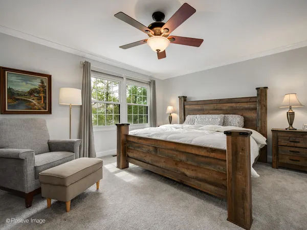 a bed sitting in a spacious bedroom next to a window