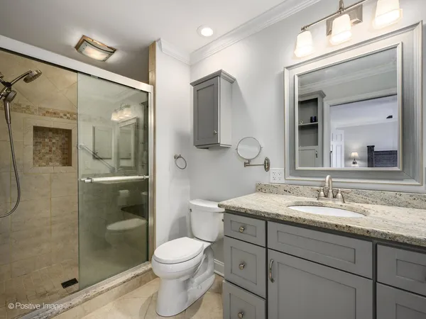 a bathroom with a shower sink vanity mirror and toilet