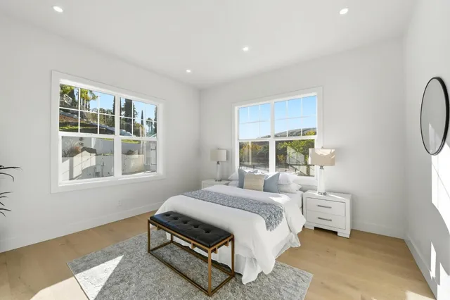 a bedroom with a bed a mirror and a window