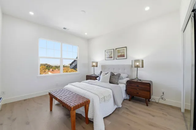 a bedroom with a bed a dresser and a painting