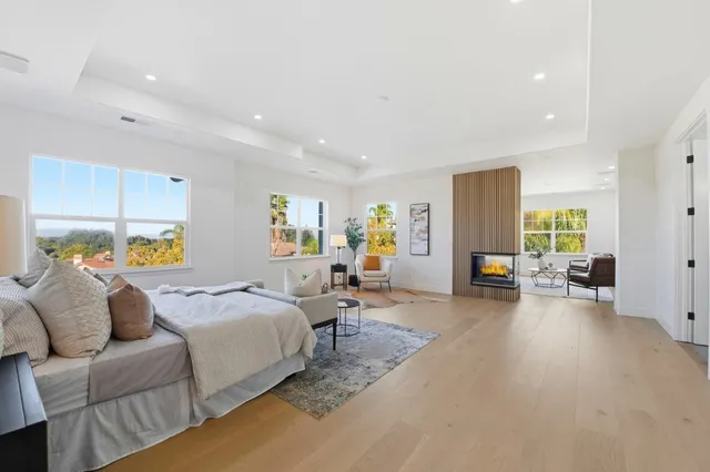 a spacious bedroom with a bed a couch and a large window