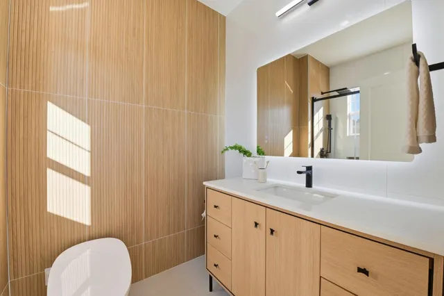 a bathroom with a granite countertop sink and a mirror