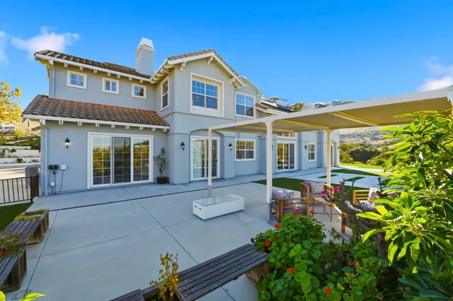 a front view of a house with a yard and potted plants