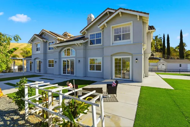 an aerial view of a house with swimming pool and outdoor seating
