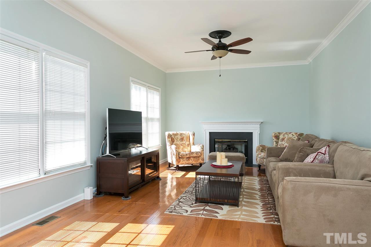 2337 Bolingbrook Lane Raleigh, NC 27613 - Photo 12 of 25 a living room with furniture a fireplace and a flat screen tv