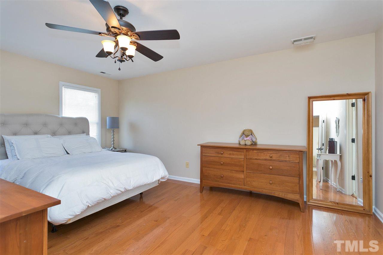 2337 Bolingbrook Lane Raleigh, NC 27613 - Photo 13 of 25 a bedroom with a bed and a chandelier