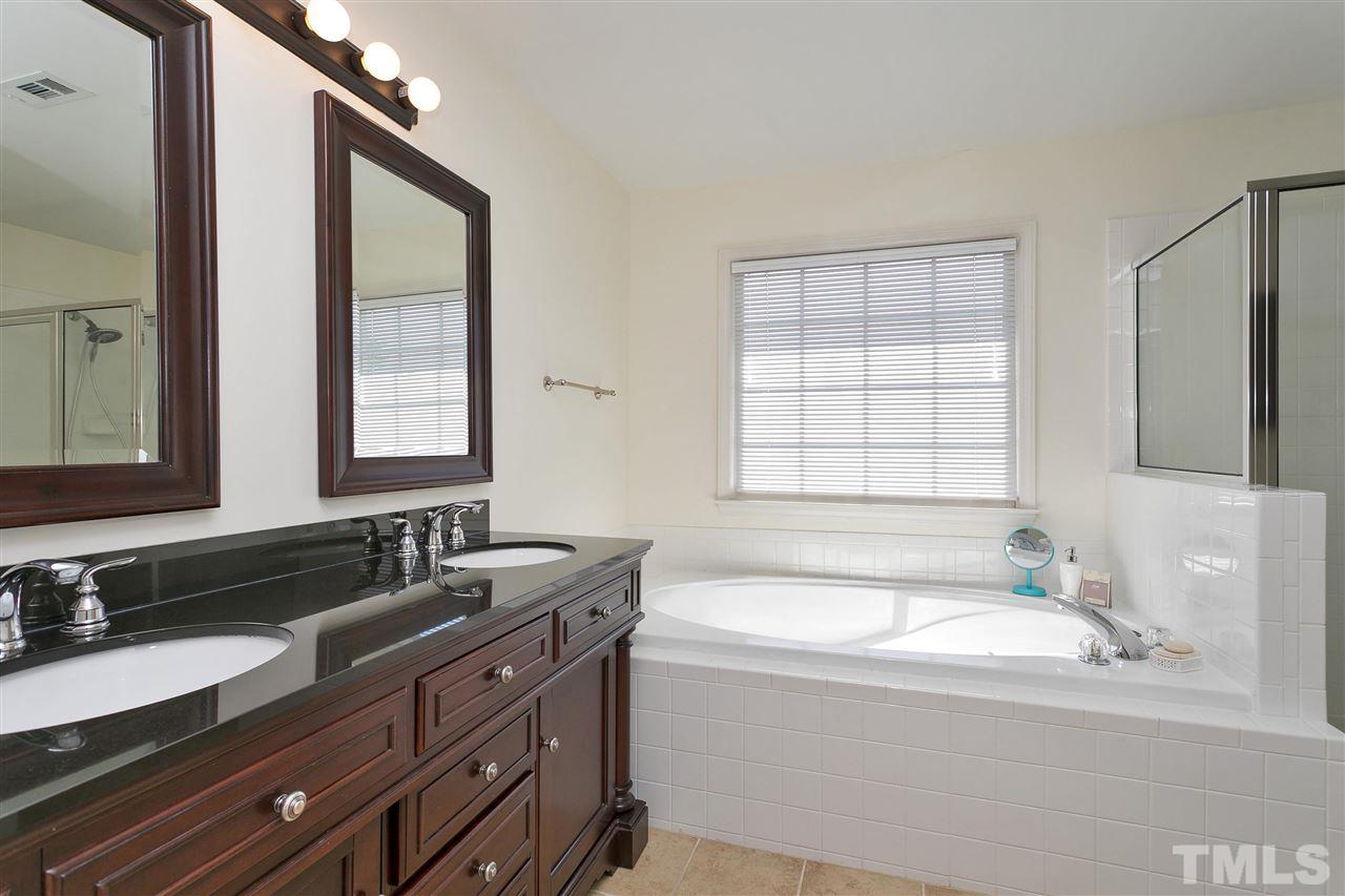 2337 Bolingbrook Lane Raleigh, NC 27613 - Photo 15 of 25 a bathroom with a granite countertop tub sink and mirror