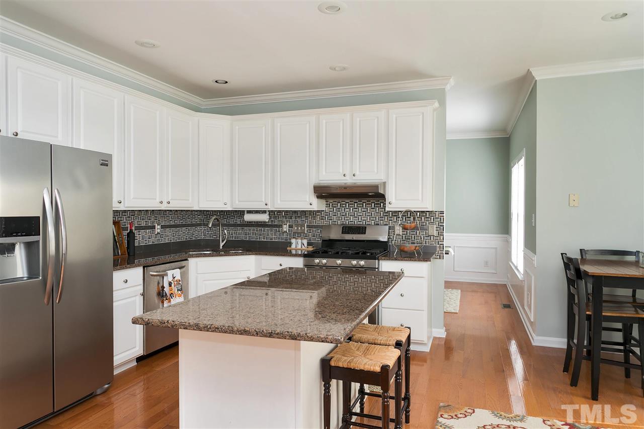 2337 Bolingbrook Lane Raleigh, NC 27613 - Photo 4 of 25 a kitchen with granite countertop stainless steel appliances a refrigerator a stove a sink a dining table and chairs