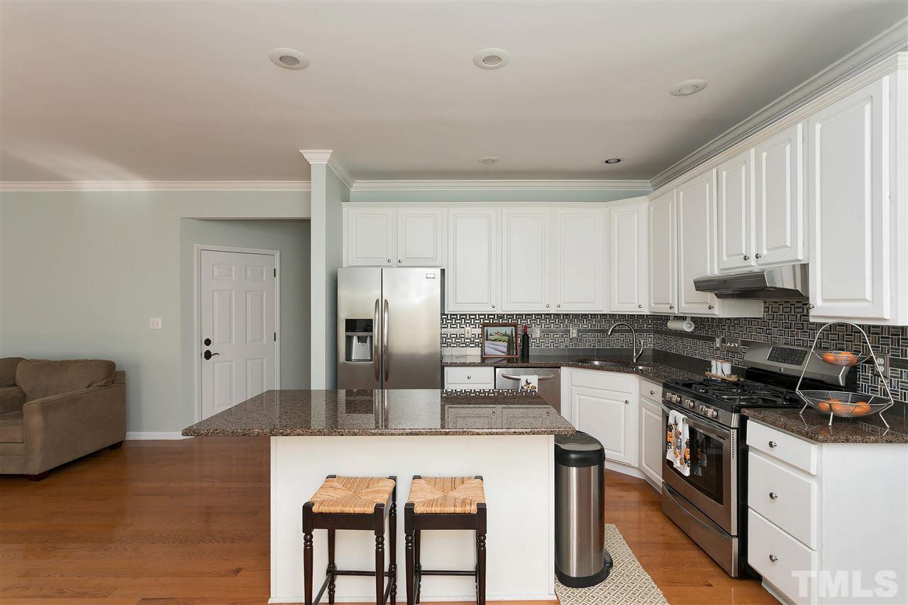 2337 Bolingbrook Lane Raleigh, NC 27613 - Photo 7 of 25 a kitchen with kitchen island a counter top space a sink stainless steel appliances and cabinets