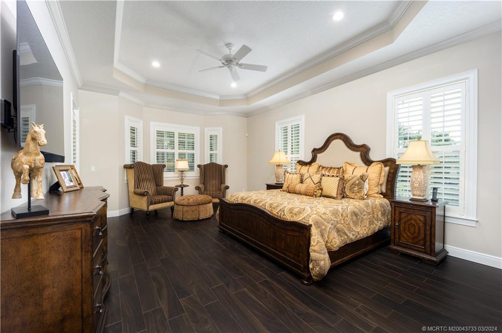 1665 Northwest Fork Road Stuart, FL 34994 - Photo 22 of 52 a spacious bedroom with a bed and wooden floor