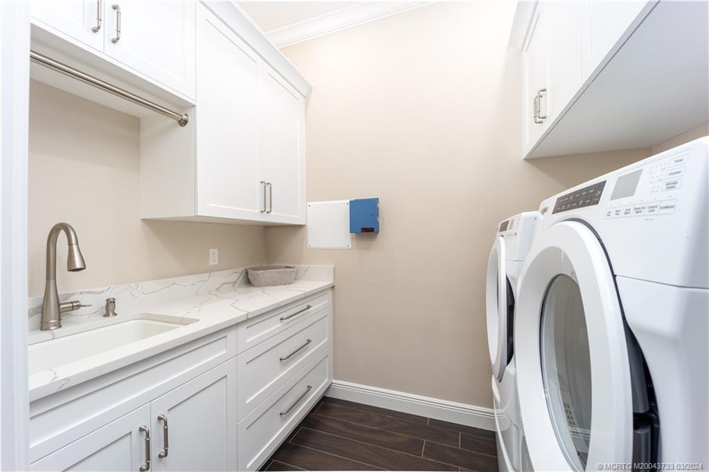 1665 Northwest Fork Road Stuart, FL 34994 - Photo 35 of 52 a bathroom with a sink a washer and dryer