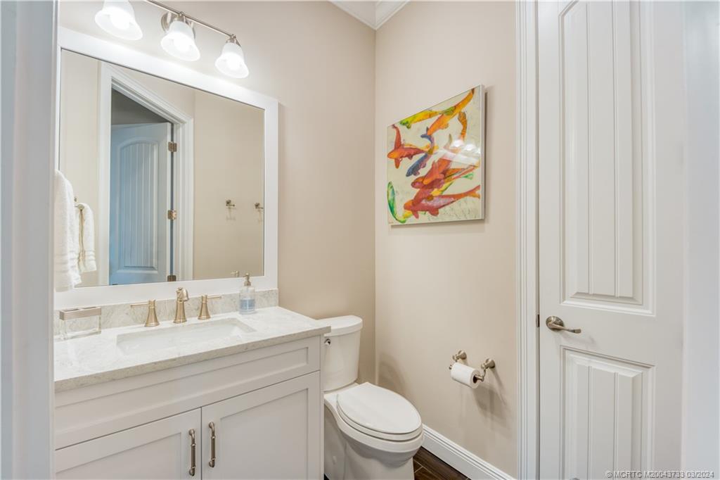 1665 Northwest Fork Road Stuart, FL 34994 - Photo 36 of 52 a bathroom with a sink a toilet and a mirror