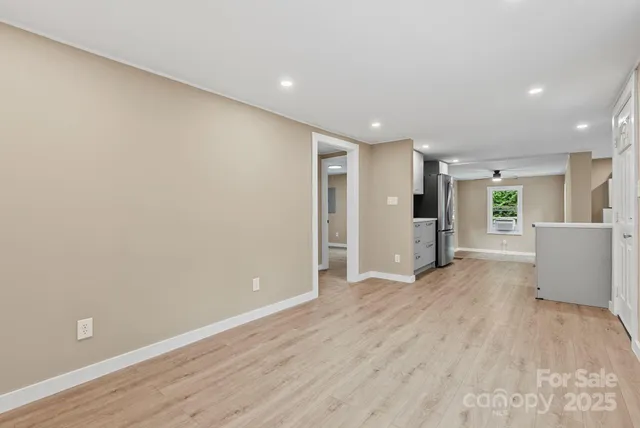 a kitchen with a refrigerator and white cabinets