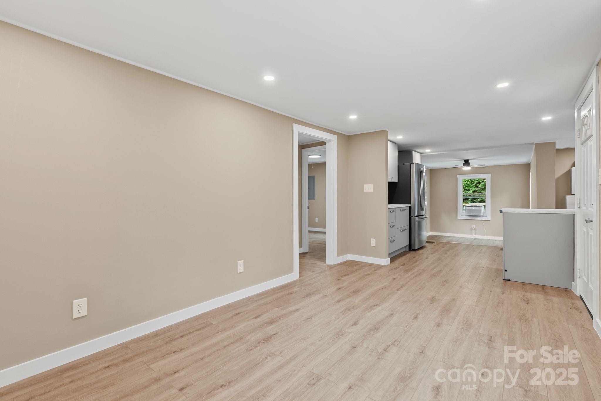 530 Rebel Ridge Road Marshall, NC 28753 - Photo 14 of 46 an empty room with wooden floor and windows