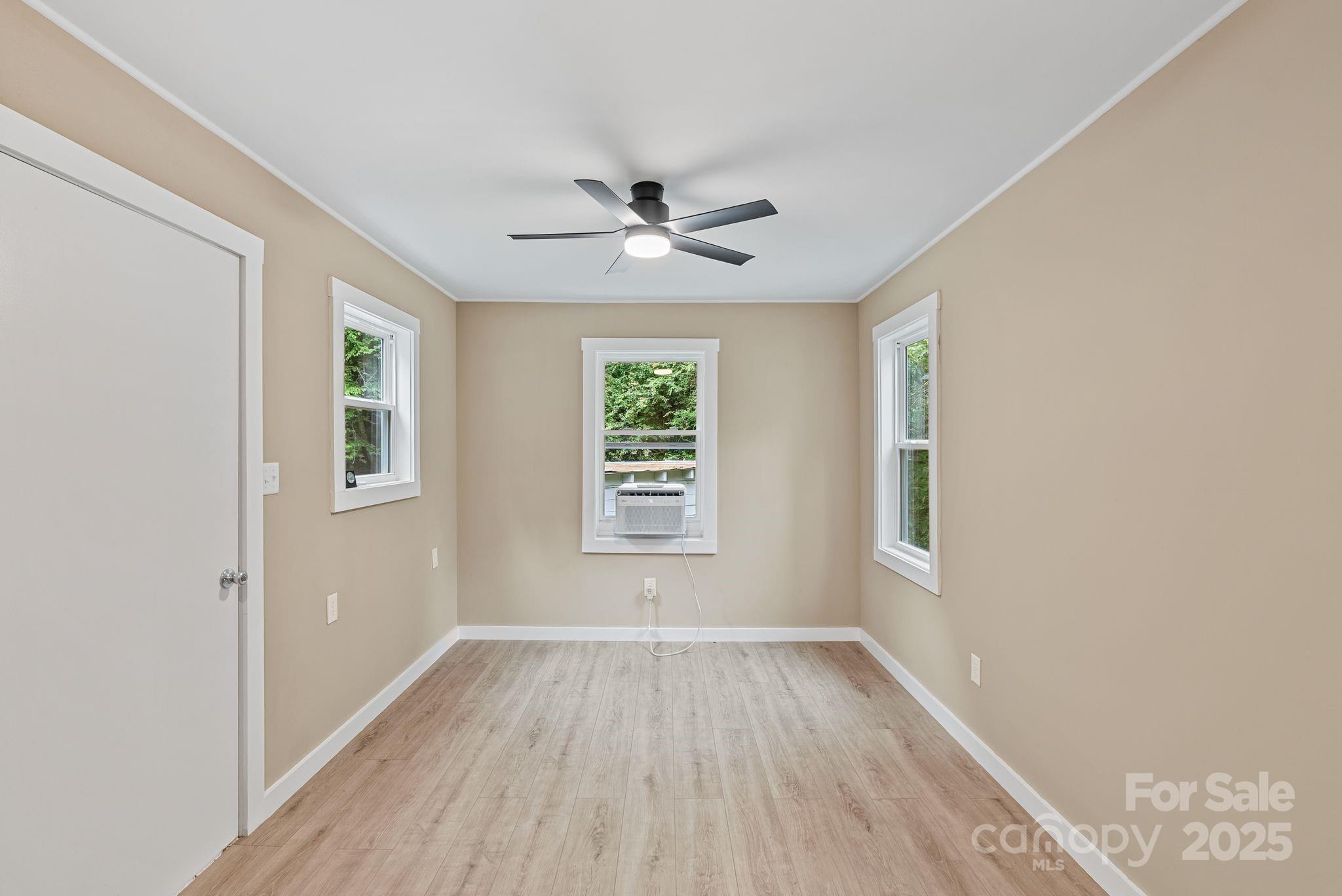 530 Rebel Ridge Road Marshall, NC 28753 - Photo 18 of 46 a view of empty room with wooden floor and fan