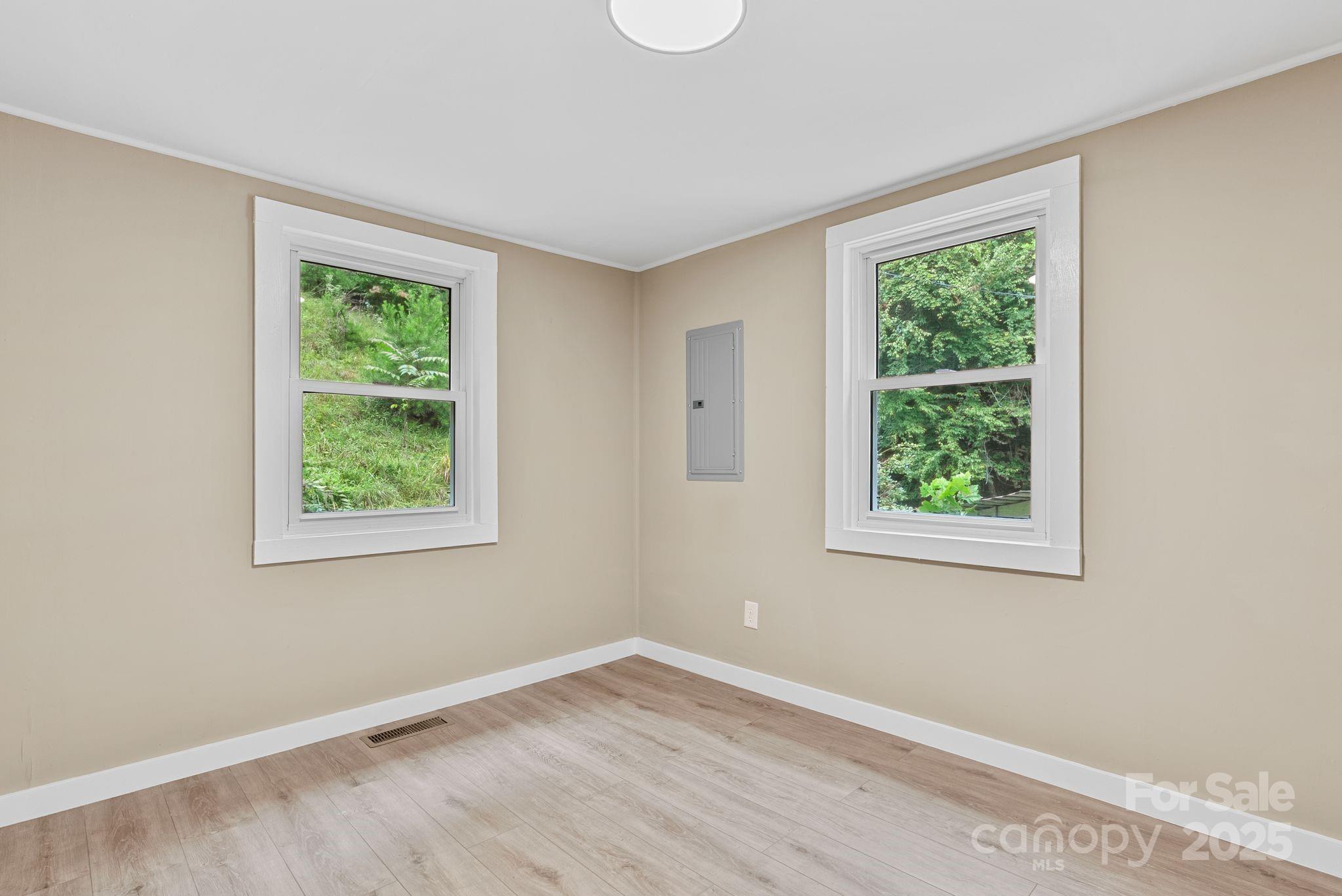 530 Rebel Ridge Road Marshall, NC 28753 - Photo 24 of 46 a view of an empty room with wooden floor and a window