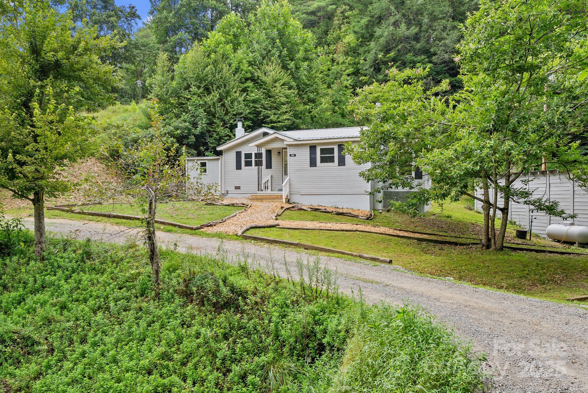 530 Rebel Ridge Road Marshall, NC 28753 - Photo 9 of 46 a house view with a sitting space and a view of a house