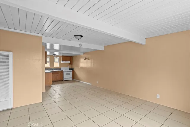 a view of a kitchen with a sink and dishwasher a oven with white cabinets