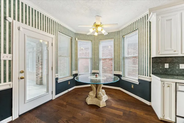 a dining room with wooden floor a chandelier a wooden table and chairs
