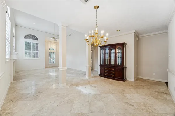a view of an empty room with chandelier and window