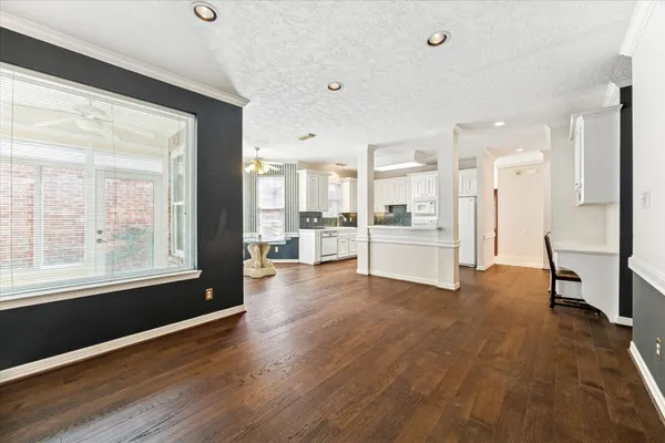 a view of a big room with wooden floor and windows