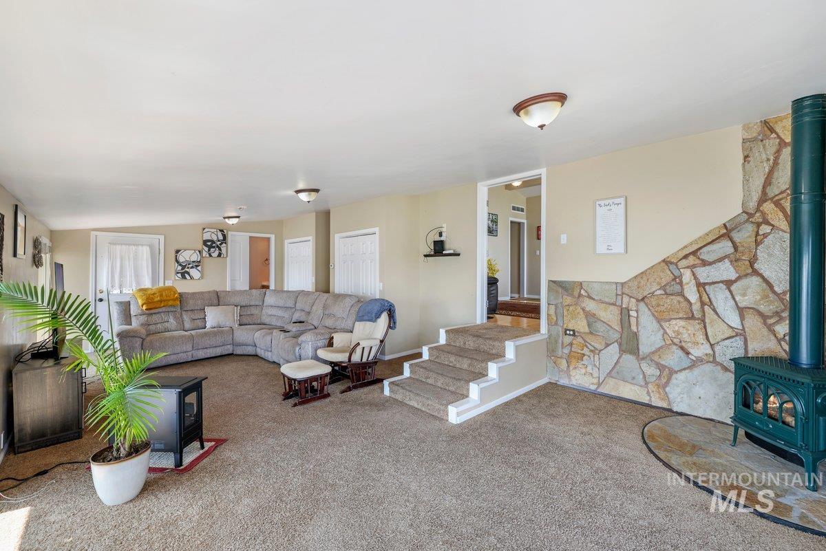 1801 Y Street Heyburn, ID 83336 - Photo 14 of 42 Carpeted living area featuring a wood stove and stairs
