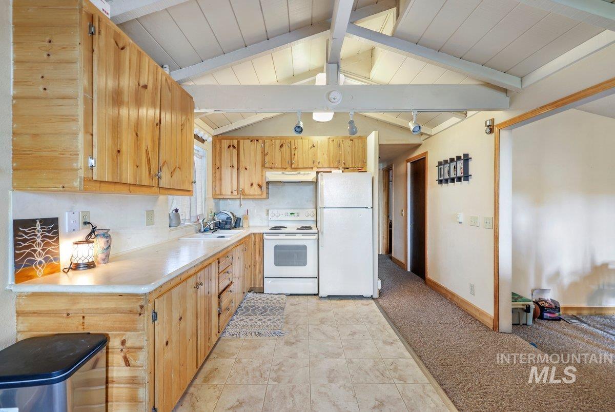 1801 Y Street Heyburn, ID 83336 - Photo 23 of 42 Kitchen featuring white appliances, light countertops, decorative backsplash, light tile patterned flooring, and light brown cabinets
