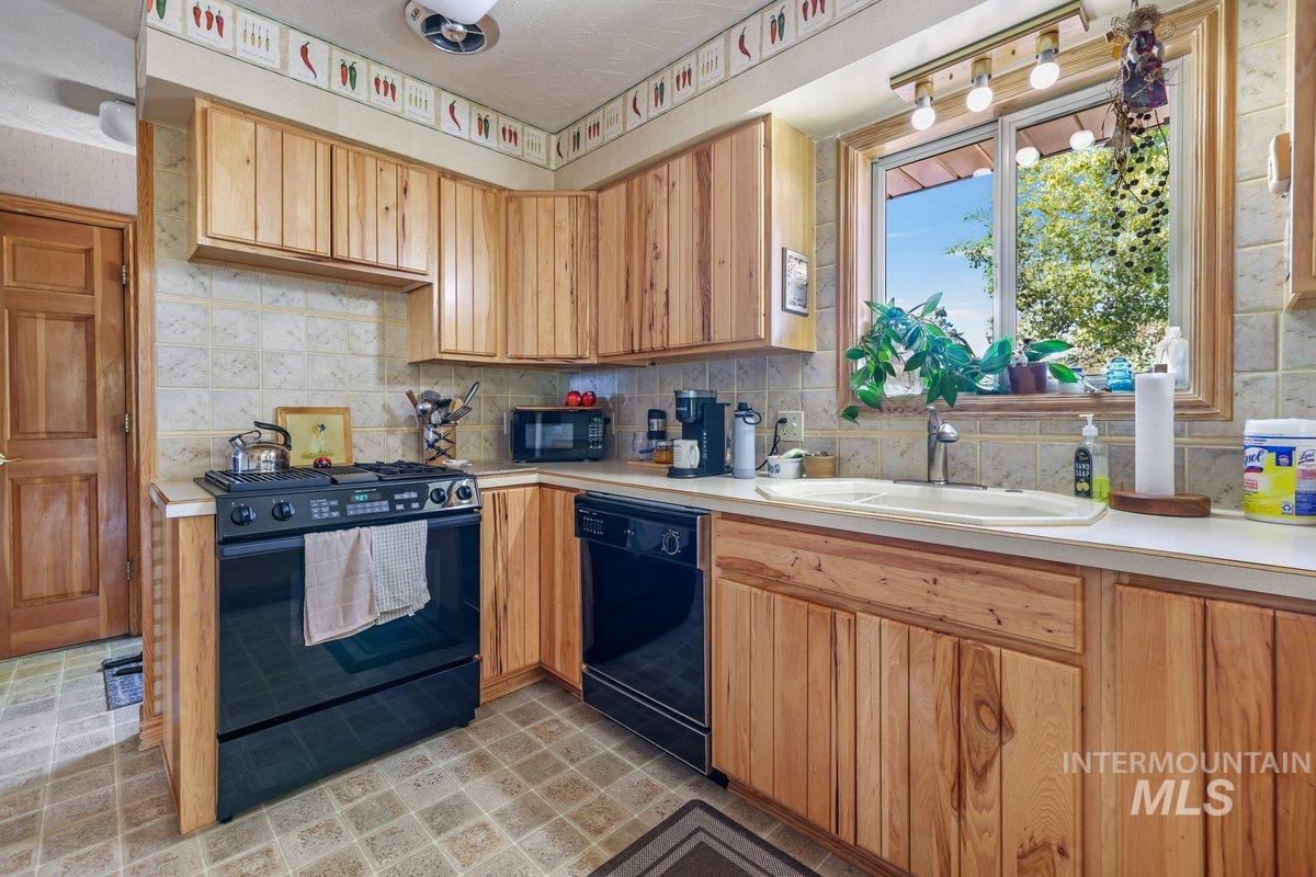 1801 Y Street Heyburn, ID 83336 - Photo 38 of 42 Kitchen with black appliances, light countertops, and decorative backsplash