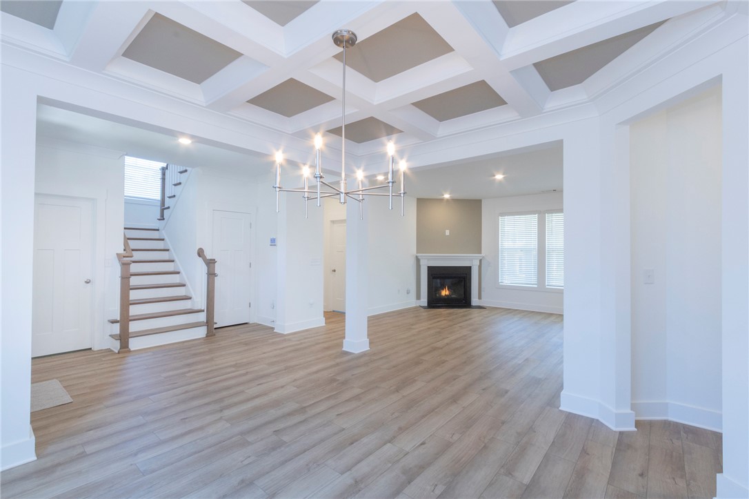 607 WH Kay Lane Anderson, SC 29621 - Photo 3 of 48 An inviting open-concept living space features a cozy fireplace and elegant coffered ceilings.