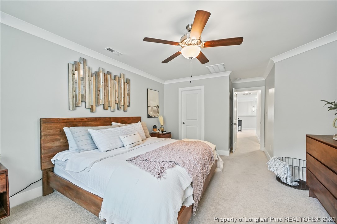 68 Spruce Hollow Circle Spring Lake, NC 28390 - Photo 24 of 48 a bedroom with a bed and a chandelier