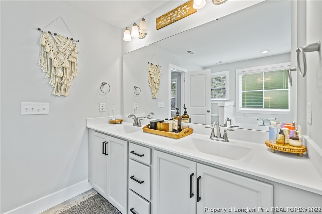 68 Spruce Hollow Circle Spring Lake, NC 28390 - Photo 28 of 48 a bathroom with a sink and a mirror