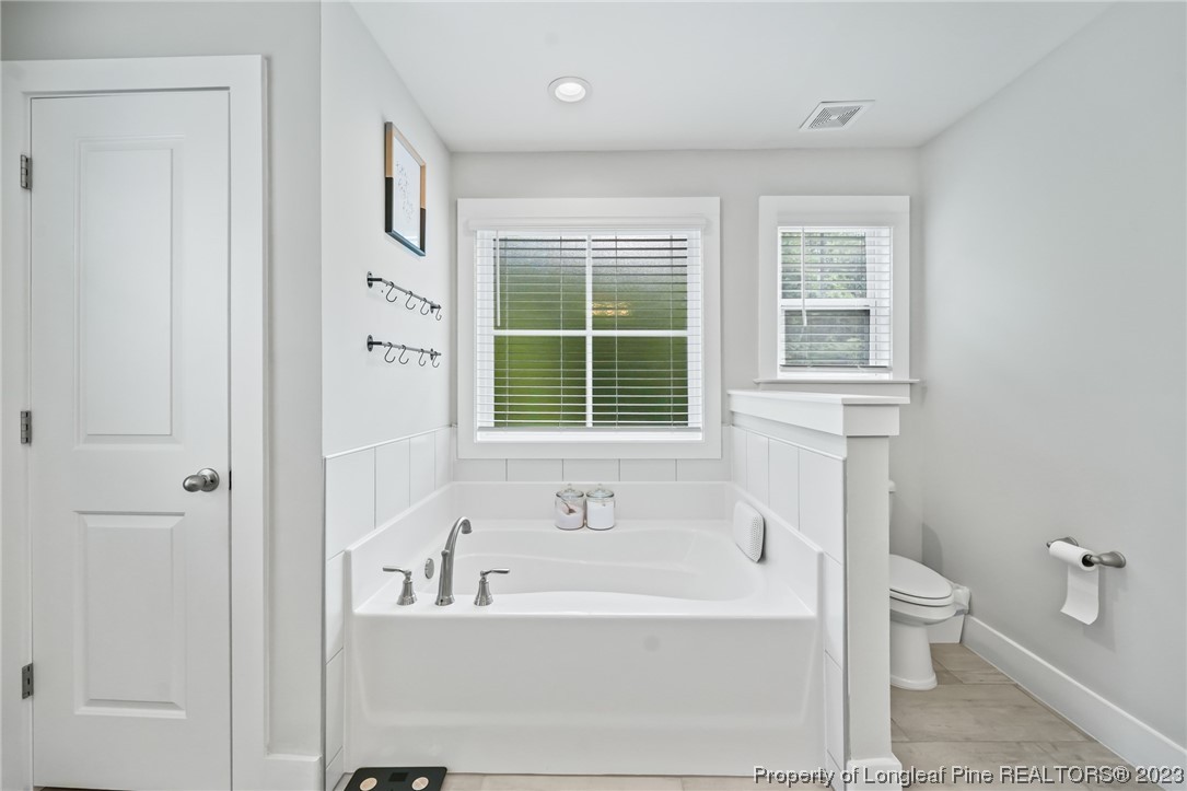 68 Spruce Hollow Circle Spring Lake, NC 28390 - Photo 29 of 48 a bathroom with a bathtub and window