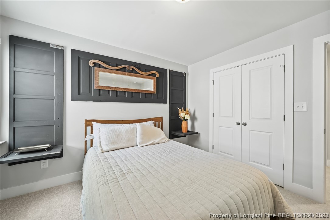 68 Spruce Hollow Circle Spring Lake, NC 28390 - Photo 31 of 48 a bedroom with a bed and a painting on the wall