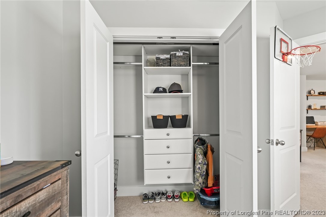68 Spruce Hollow Circle Spring Lake, NC 28390 - Photo 35 of 48 a view of walk in closet with clothes and shoes