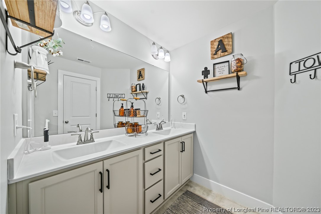 68 Spruce Hollow Circle Spring Lake, NC 28390 - Photo 36 of 48 a bathroom with a sink and a mirror