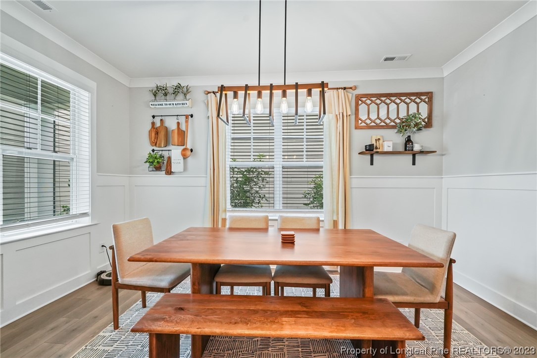 68 Spruce Hollow Circle Spring Lake, NC 28390 - Photo 4 of 48 a view of a dining room with furniture window and wooden floor